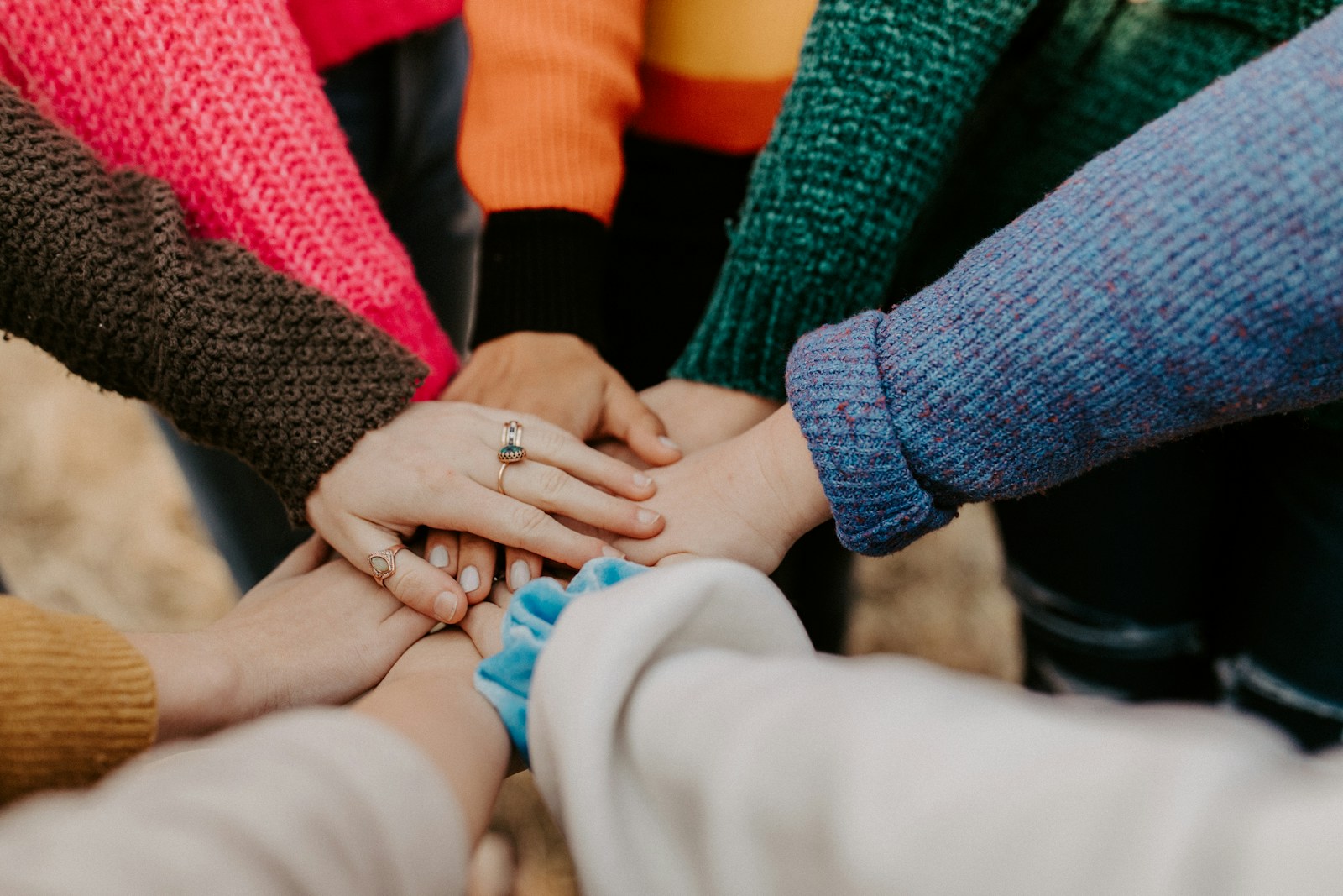 Multiple hands in a circle for a team huddle