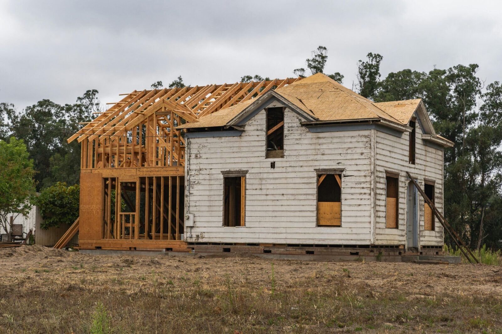Image of an old house under renovation with new wooden frame structure.